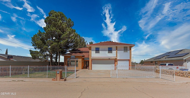9769 Galilee Dr, El Paso, TX 79927 - view of front of home with an attached garage, a fenced front yard, a gate, concrete driveway, and stucco siding