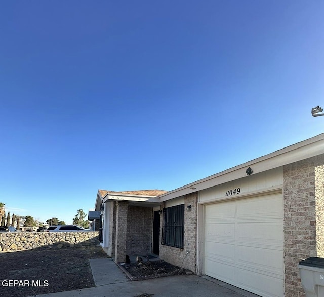 11049 Middledale St, El Paso, TX 79934 - view of property exterior with an attached garage and brick siding