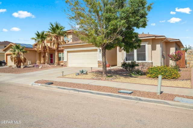11202 Redstone Peak Place, El Paso, TX 79934 - obstructed view of property with stucco siding, an attached garage, stone siding, and driveway