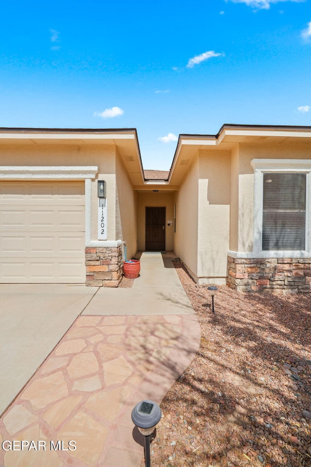 11202 Redstone Peak Place, El Paso, TX 79934 - view of front facade featuring stucco siding, stone siding, an attached garage, and concrete driveway