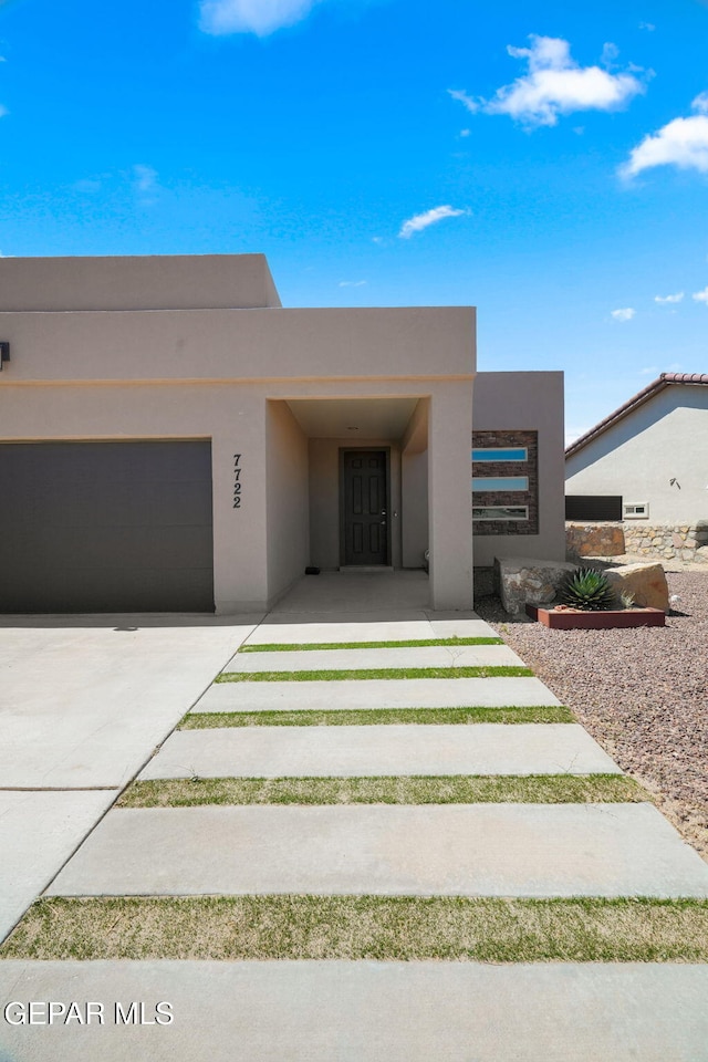 7722 Enchanted Ridge Dr, El Paso, TX 79911 - view of front facade featuring stucco siding, concrete driveway, and a garage