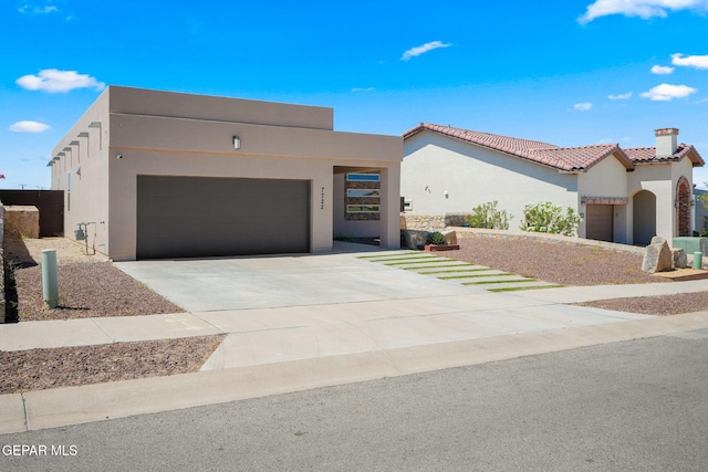 7722 Enchanted Ridge Dr, El Paso, TX 79911 - view of front of home featuring a garage, stucco siding, driveway, a tiled roof, and a chimney