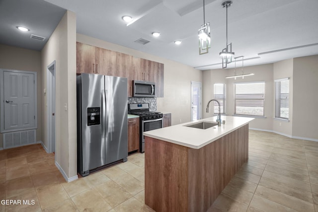 7722 Enchanted Ridge Dr, El Paso, TX 79911 - kitchen with stainless steel appliances, brown cabinets, light tile patterned flooring, light countertops, and tasteful backsplash