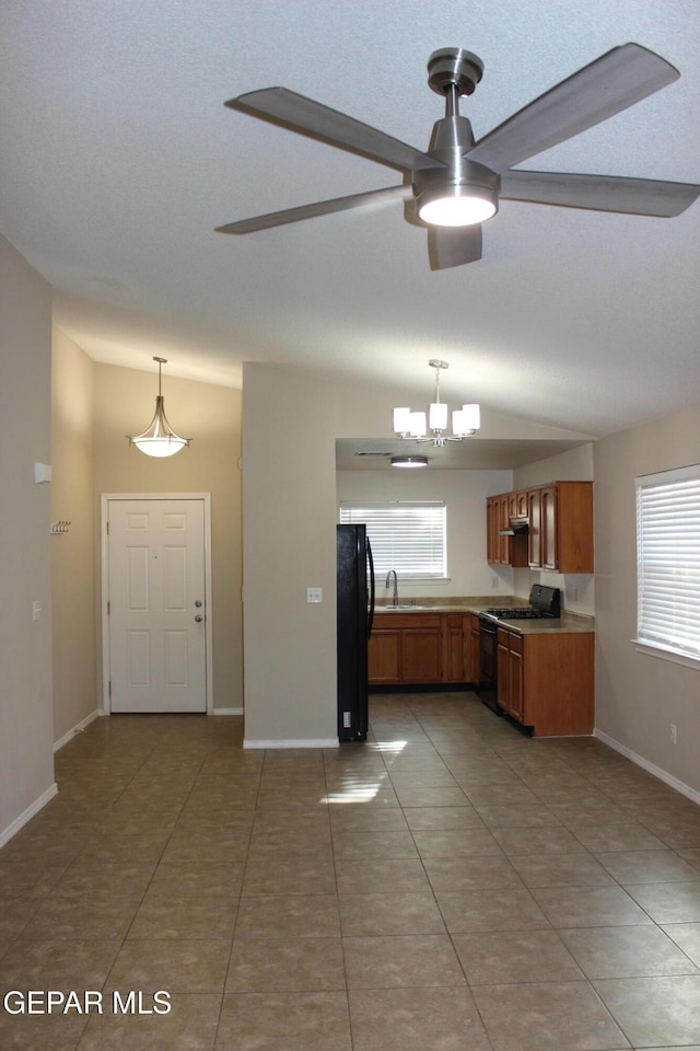 13978 Vaquero Rock Dr, El Paso, TX 79938 - kitchen with black appliances, ceiling fan, brown cabinets, lofted ceiling, and plenty of natural light