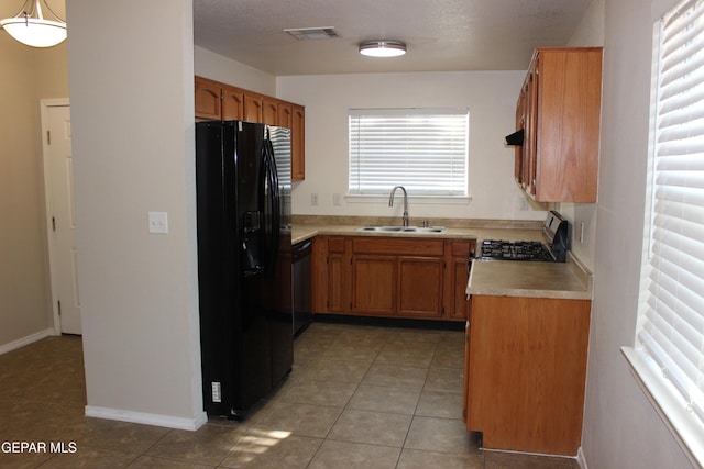 13978 Vaquero Rock Dr, El Paso, TX 79938 - kitchen with black refrigerator with ice dispenser, range with gas cooktop, dishwasher, light countertops, and light tile patterned flooring