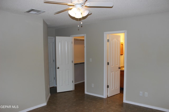 13978 Vaquero Rock Dr, El Paso, TX 79938 - unfurnished bedroom with a walk in closet, a textured ceiling, a closet, ensuite bath, and dark tile patterned flooring