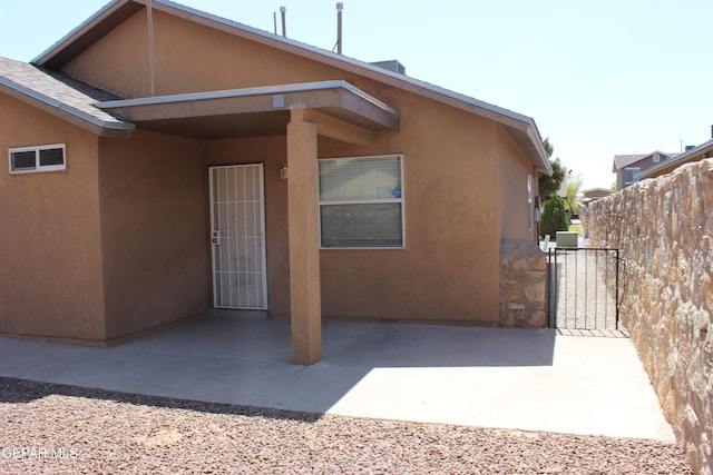 13978 Vaquero Rock Dr, El Paso, TX 79938 - view of home's exterior featuring stucco siding, a patio area, and a gate