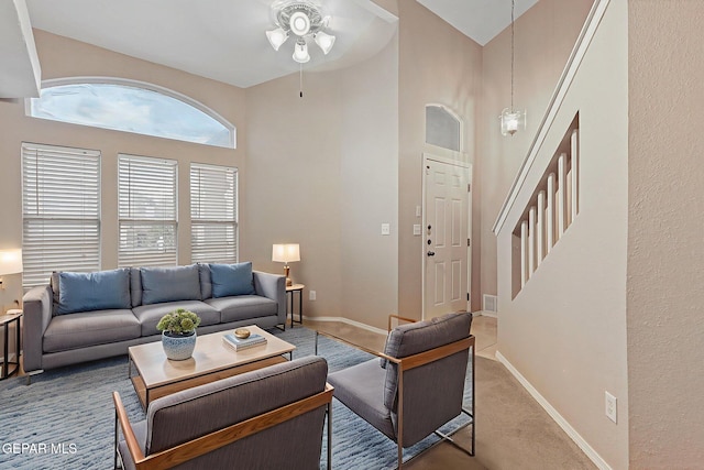6736 Dakota Ridge Dr, El Paso, TX 79912 - carpeted living room featuring a ceiling fan, a high ceiling, and stairs