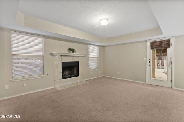 6736 Dakota Ridge Dr, El Paso, TX 79912 - unfurnished living room with a tray ceiling, carpet, and a tiled fireplace