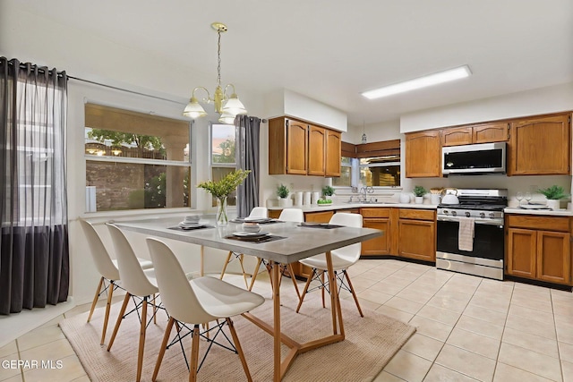 6736 Dakota Ridge Dr, El Paso, TX 79912 - kitchen with stainless steel appliances, light countertops, light tile patterned flooring, and healthy amount of natural light