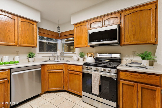 6736 Dakota Ridge Dr, El Paso, TX 79912 - kitchen with stainless steel appliances, light tile patterned floors, light countertops, and brown cabinets