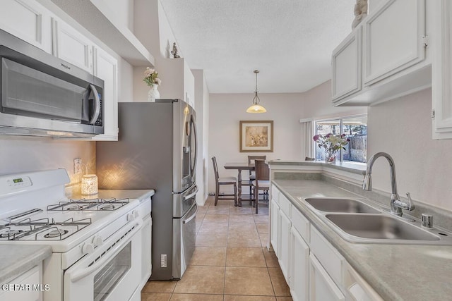 3280 Fawn Passage Place, El Paso, TX 79936 - kitchen with gas range gas stove, stainless steel microwave, white cabinets, light countertops, and light tile patterned flooring