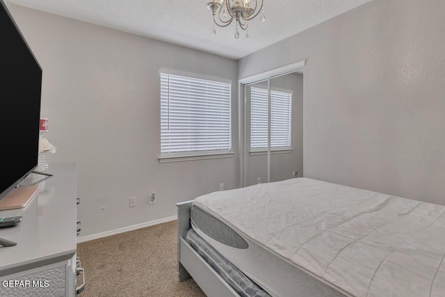 3280 Fawn Passage Place, El Paso, TX 79936 - bedroom with carpet, a chandelier, a closet, and a textured ceiling