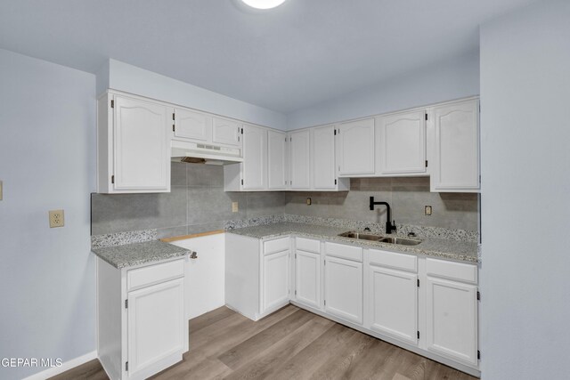 231 Romeria Dr, El Paso, TX 79907 - kitchen with under cabinet range hood, backsplash, and white cabinetry