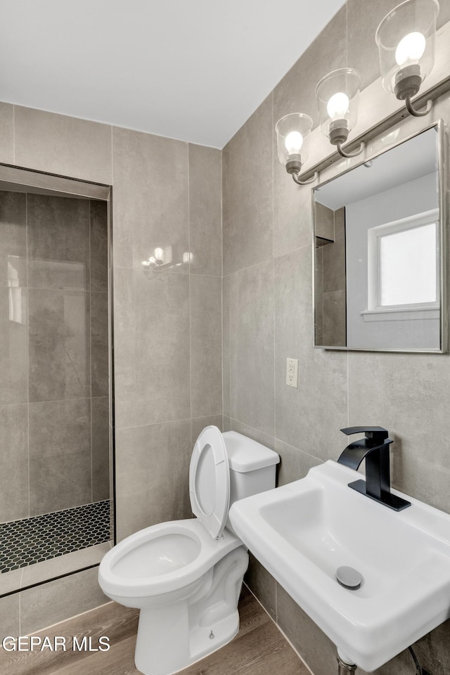 231 Romeria Dr, El Paso, TX 79907 - bathroom featuring tile walls, wood finished floors, and a tile shower