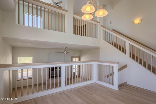 3148 Tierra Encino Dr, El Paso, TX 79938 - staircase with ceiling fan, wood finished floors, a high ceiling, and a chandelier