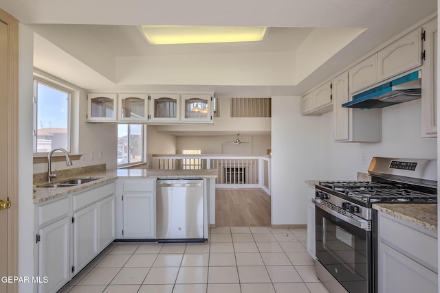3148 Tierra Encino Dr, El Paso, TX 79938 - kitchen with stainless steel appliances, under cabinet range hood, a raised ceiling, a peninsula, and light stone counters