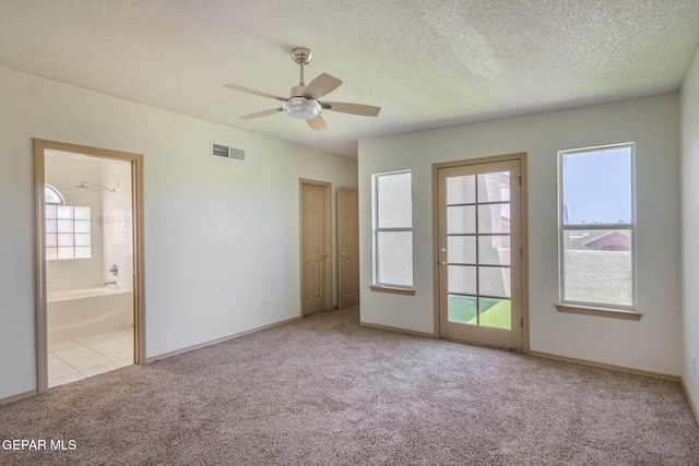 3148 Tierra Encino Dr, El Paso, TX 79938 - unfurnished bedroom with carpet flooring, multiple windows, ensuite bathroom, a textured ceiling, and a ceiling fan