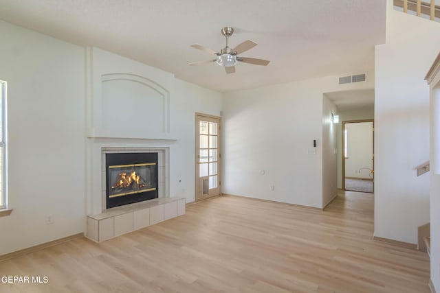 3148 Tierra Encino Dr, El Paso, TX 79938 - unfurnished living room featuring a ceiling fan, light wood finished floors, and a tiled fireplace