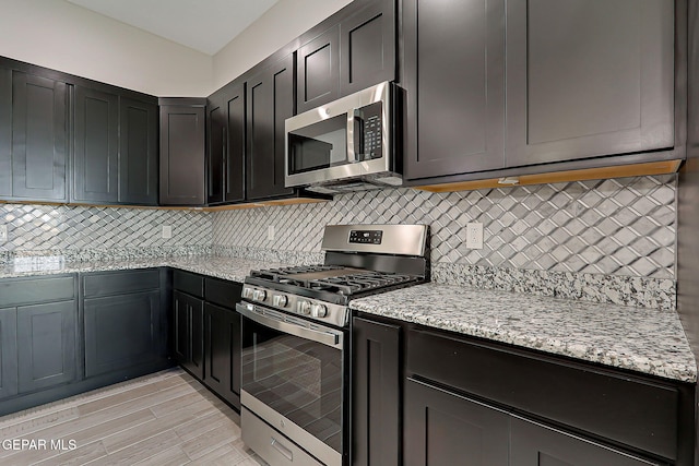 13860 Summer View Ave, El Paso, TX 79928 - kitchen with appliances with stainless steel finishes, light stone countertops, and backsplash