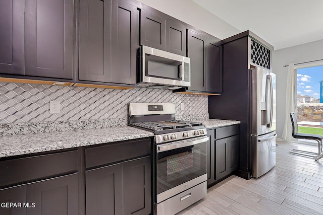 13860 Summer View Ave, El Paso, TX 79928 - kitchen featuring stainless steel appliances, decorative backsplash, light stone counters, and light wood-style flooring