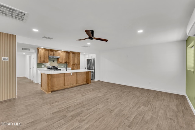 10229 Luella Ave, El Paso, TX 79925 - kitchen with appliances with stainless steel finishes, light countertops, a ceiling fan, under cabinet range hood, and light wood-style floors