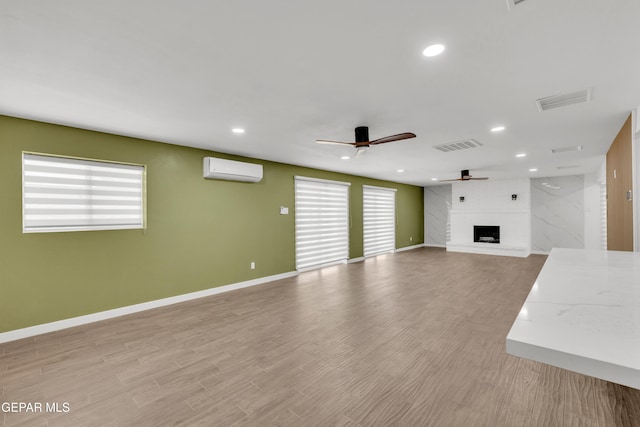 10229 Luella Ave, El Paso, TX 79925 - unfurnished living room with a ceiling fan, an AC wall unit, a fireplace, recessed lighting, and light wood finished floors