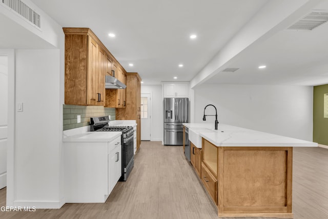 10229 Luella Ave, El Paso, TX 79925 - kitchen featuring appliances with stainless steel finishes, ventilation hood, light wood-style floors, decorative backsplash, and recessed lighting