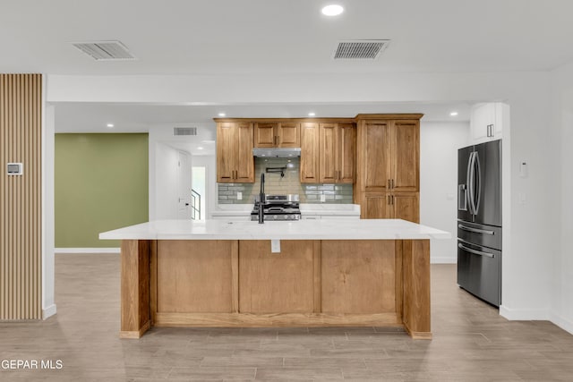 10229 Luella Ave, El Paso, TX 79925 - kitchen featuring appliances with stainless steel finishes, under cabinet range hood, light countertops, recessed lighting, and tasteful backsplash