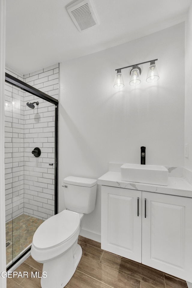 10229 Luella Ave, El Paso, TX 79925 - bathroom featuring a shower stall, wood finished floors, and vanity