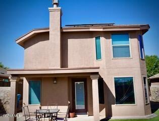 13643 Pecos River Rd, Clint, TX 79836 - rear view of property featuring stucco siding, a chimney, a patio area, and outdoor dining space