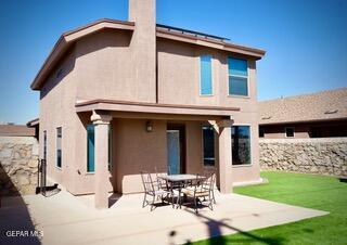 13643 Pecos River Rd, Clint, TX 79836 - rear view of property featuring a patio, stucco siding, a chimney, and a lawn