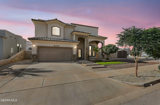 12511 Furlong Cir, El Paso, TX 79928 - mediterranean / spanish house featuring stone siding, stucco siding, a garage, and driveway