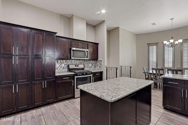 12511 Furlong Cir, El Paso, TX 79928 - kitchen with appliances with stainless steel finishes, a chandelier, tasteful backsplash, hanging light fixtures, and a kitchen island