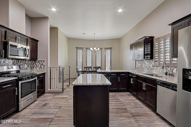 12511 Furlong Cir, El Paso, TX 79928 - kitchen featuring appliances with stainless steel finishes, a chandelier, tasteful backsplash, dark brown cabinets, and light stone countertops