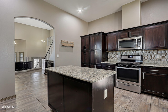 12511 Furlong Cir, El Paso, TX 79928 - kitchen with stainless steel appliances, tasteful backsplash, a center island, and light stone countertops