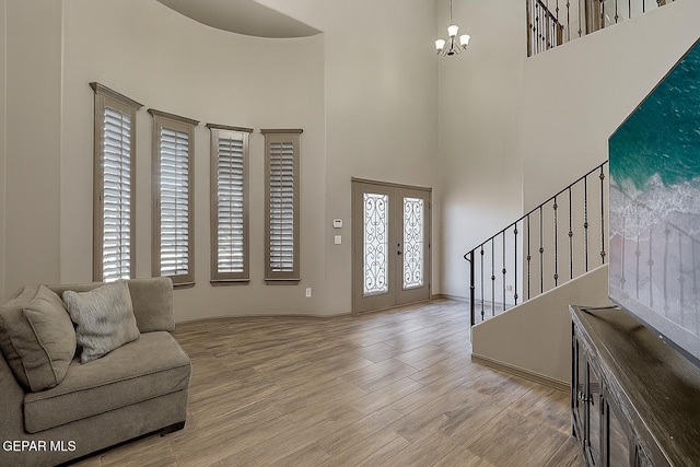 12511 Furlong Cir, El Paso, TX 79928 - foyer entrance with a high ceiling, french doors, stairs, light wood-style floors, and a chandelier