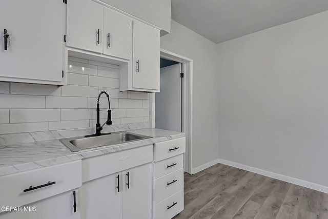 209 Hardesty Pl, El Paso, TX 79905 - kitchen with decorative backsplash, white cabinetry, and light wood finished floors