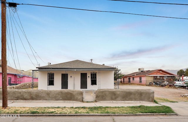 209 Hardesty Pl, El Paso, TX 79905 - bungalow-style house featuring a fenced front yard, a porch, stucco siding, a shingled roof, and a gate