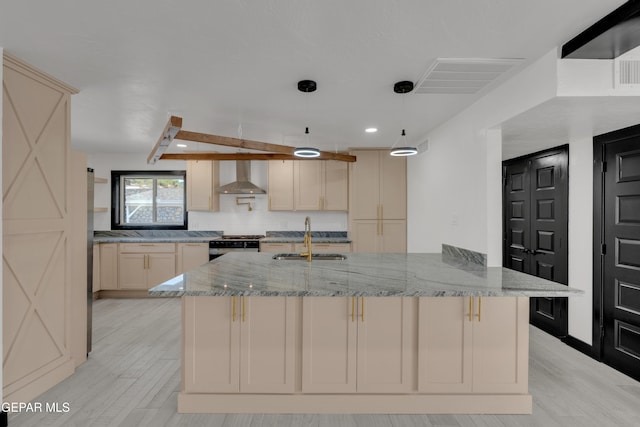3116 Titanic Ave, El Paso, TX 79904 - kitchen with wall chimney exhaust hood, light wood finished floors, light stone counters, recessed lighting, and cream cabinets