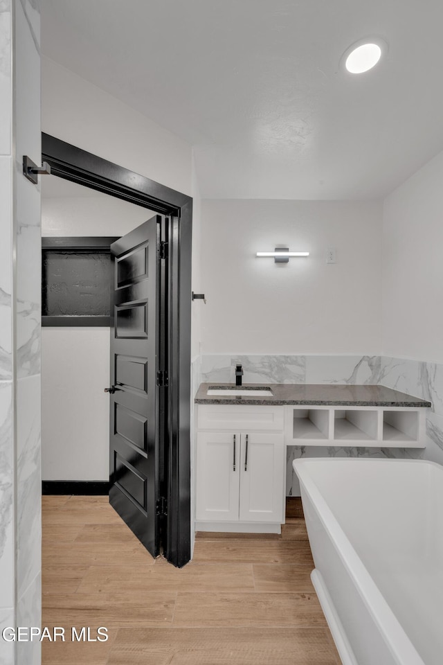 3116 Titanic Ave, El Paso, TX 79904 - full bathroom with a freestanding tub, vanity, and wood finished floors