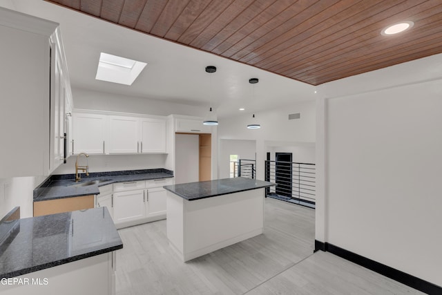 3116 Titanic Ave, El Paso, TX 79904 - kitchen featuring a skylight, wood ceiling, white cabinetry, a kitchen island, and pendant lighting