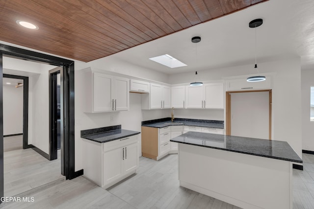 3116 Titanic Ave, El Paso, TX 79904 - kitchen with a skylight, white cabinets, pendant lighting, recessed lighting, and light wood finished floors