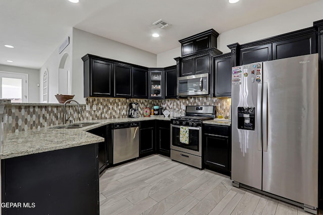 13120 Wesleyan, El Paso, TX 79928 - kitchen with stainless steel appliances, dark cabinets, light stone countertops, backsplash, and recessed lighting
