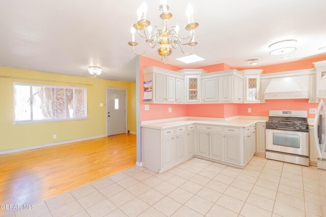 10324 Shoshone St, El Paso, TX 79924 - kitchen featuring appliances with stainless steel finishes, custom range hood, light countertops, and a chandelier