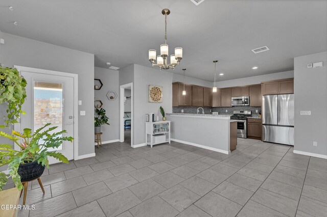 203 Bretby Pl, El Paso, TX 79928 - kitchen featuring stainless steel appliances, backsplash, a chandelier, a peninsula, and light tile patterned floors