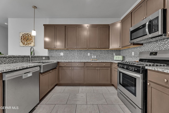 203 Bretby Pl, El Paso, TX 79928 - kitchen featuring stainless steel appliances, backsplash, light stone countertops, and hanging light fixtures