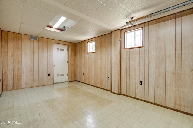 10317 Wilshire Dr, El Paso, TX 79924 - basement with tile patterned floors, wood walls, and healthy amount of natural light