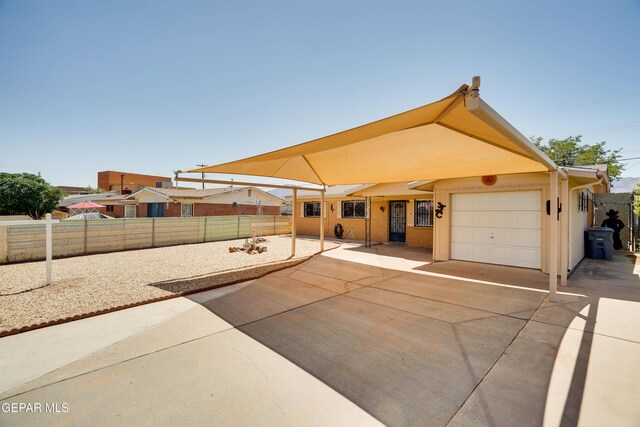 10317 Wilshire Dr, El Paso, TX 79924 - view of front of property with concrete driveway, a fenced backyard, a carport, and an attached garage