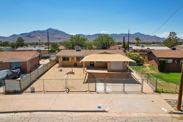 10317 Wilshire Dr, El Paso, TX 79924 - view of front facade with concrete driveway, a fenced front yard, a gate, and a mountain view